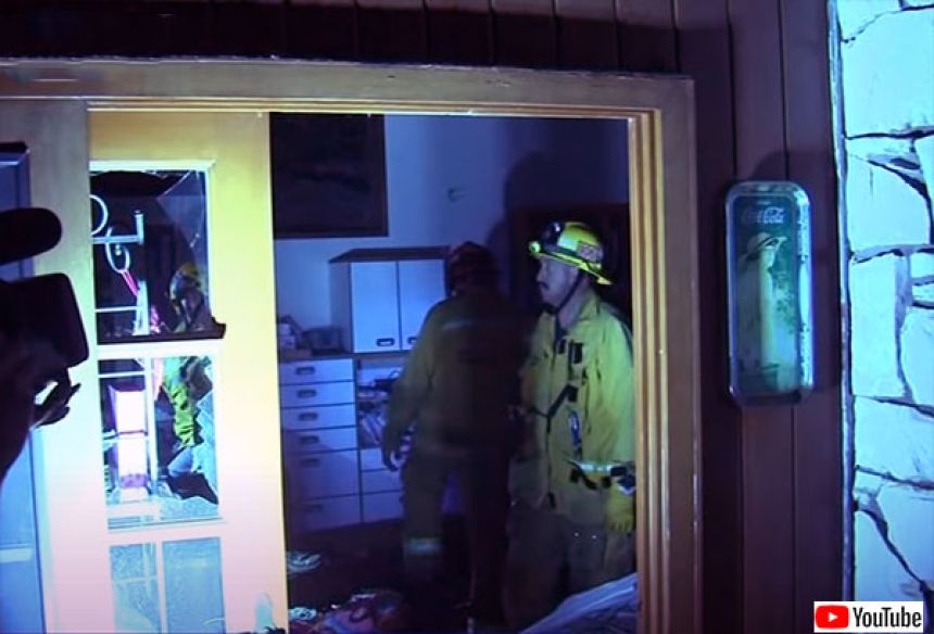 事故現場となった家の中を調査する消防局
